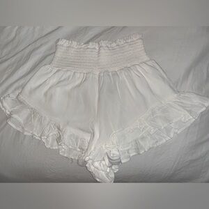 White flowy shorts with ruffle like trim.